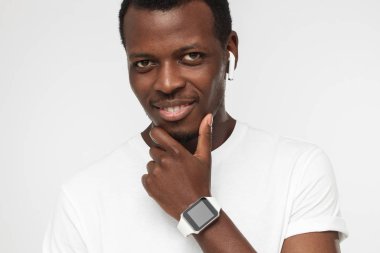 Şık modern akıllı saati boş ekran ile gösterilen gri arka plan üzerinde izole boş Beyaz tişörtlü, yakışıklı Afrikalı-Amerikalı adam portresi kapatın