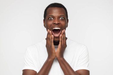 Boş beyaz t gömlek oh bağırarak içinde genç Afro-Amerikan adam gri arka plan üzerine açık ağız, düşük fiyat ve satış, tarafından sürpriz benim Tanrıyla izole