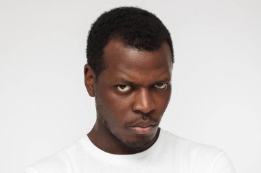 Portre fotoğraf makinesi vasıl öfke ile seyir Afrikalı-Amerikalı gencin boş beyaz t gömlek gri arka plan üzerinde izole kapatmak