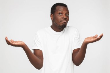 Bilmiyorum. O ne yapacağını bilmiyor sanki çaresiz jest kol ve el ile gösterilen zararına, gri arka plan olarak izole genç afrcian Amerikalı adam