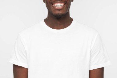 Boş beyaz t-shirt üzerinde açık gri renkli izole yakışıklı Afro-Amerikan erkek gülümseyen portresi kapatın
