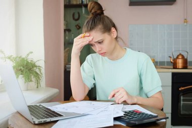Avrupa beyaz seyir yorgun ve bıkkın finansal kağıtları Tapınağı, umutsuzluk ve baş ağrısı için parmak basarak hayal kırıklığı ile ilgili mutfak masasında oturan kadın kapalı resmi