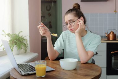 Kahvaltı, masanın üzerinde emin değilim ne duygu gündüz, sıkılmış açık yatan onu laptop yerken yatay seyir sabah mutfakta oturmuş çekici beyaz kız portresi yorgun