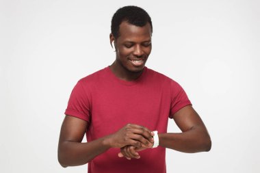 Onun yeni dijital ayarlarını değiştirmeye çalışıyorum resimde izole üzerinde gri arka plan tam olarak, gerekli verileri göstermek dikkat ve yaşam kolaylaştırmak genç adam koyu tenli yatay closeup