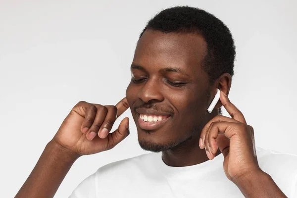 아프리카 남자의 얼굴만 Leftwards 배경에 새로운 이어폰 매혹과 사운드 품질을 — 스톡 사진