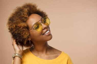 Afrikalı kadın model stüdyo çekim üzerinde izole kahverengi backrgound, metniniz için kopya alanı ile gülümseyen 