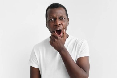 Young african american man isolated on grey background, with eyes wide open with fear or amazement, covering open mouth with palm, astounded with news clipart