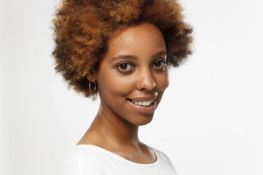 Afro-Amerikan erkek altın küpe ve yüzük Görüntüleyici güven, sakinlik ve iyimserlik duygusu ile seyir burun giyiyor gri arka plan karşı izole ayakta kapalı closeup