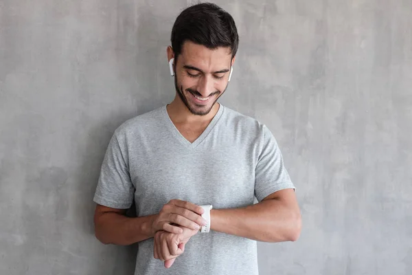 Joven Hombre Guapo Con Auriculares Inalámbricos Camiseta Comprobación Relojes Inteligentes — Foto de Stock