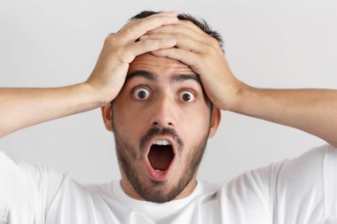 Yuvarlak yukarı korku, güçlü ifade ile gri arka plan üzerinde izole genç adamın gözleri, ağzı, şaşkınlık ve şok gösterilen açık yakın