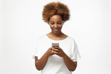 Genç Afro-Amerikan hipster kadında boş beyaz t gömlek, üzerinde izole gri arka plan, manifatura ya da mutlu rahat gülümseme ile tarama