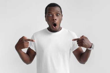 İçerik boş t-shirt şok yüz ile giyen bir şey büyük reklam kopya alanı üzerinde çizim gri arka plan üzerinde izole duygusal Afrikalı-Amerikalı adam