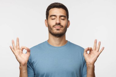 Yoga ve meditasyon kavramı. Kapalı gözlerle ayakta, denge ve uyum gri izole bulmaya rahatlama meditasyon, süre sahip konsantre rahat adam