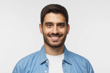 Gri arka plan üzerinde izole mavi gömlek gülümseyen yakışıklı adam