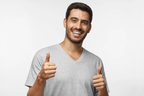 Young Laughing Man Isolated Grey Background Showing Thumb Sup Positive — Stock Photo, Image