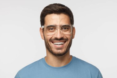 Yüksek sesle kavramı gülüyor. Neşeli modern genç mavi t-shirt gülümsüyor içinde geniş, adam gülüyor, mükemmel beyaz dişler gösteriliyor. 