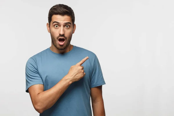 Jovem Surpreso Homem Camiseta Azul Apontando Para Direita Com Dedo — Fotografia de Stock