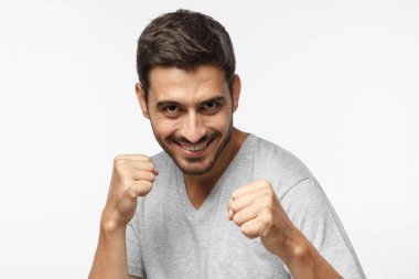 Gülümseyerek kameraya bakarak yumruklarını hazır tutmak için mücadele ve kendini savunma, boks, gülümseyen genç adam portresi kapatın