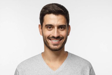 Gri arka plan üzerinde izole gülümseyen yakışıklı adam