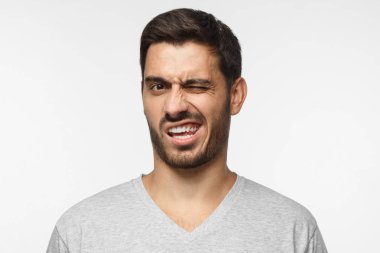 Ugh, iğrenç! Bir şey kötü ve kötü, gri arka plan üzerinde izole bakarak şok genç adam. Negatif duygu kavramı