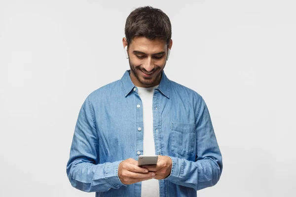 Joven Hombre Pie Aislado Fondo Gris Mirando Pantalla Del Teléfono —  Fotos de Stock