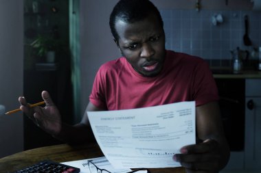 Faturaları kavramı ödeme. Stresli Afrikalı-Amerikalı adam don't understand büyük meblağlar onun faturalarını muhasebe, bu rakamlar doğru bir hata için arıyoruz inanıyorum mümkün kontrol