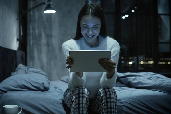 Jovem Sorrindo Mulher Sentada Sua Cama Com Tablet Digital Assistindo — Fotografia de Stock