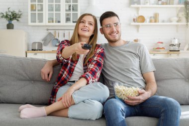 Genç mutlu aile mutfak at kanepede oturup tv izlemek