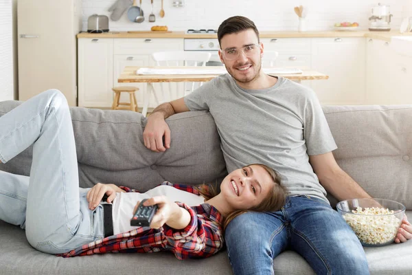 年轻的微笑的夫妇在家里的沙发上看电视 — 图库照片