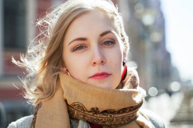 Şehrin arka planda sonbaharda ciddi bir kız portresi. Bir eşarp ve kırmızı ruj kamera bakarak moda kadınlar
