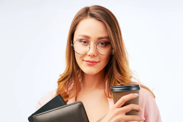 Student håller takeaway cappuccino och anteckningsbok — Stockfoto