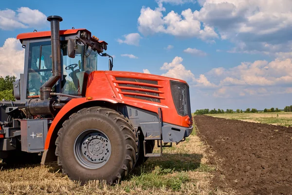 Tractor plows field, cultivators soil for sowing