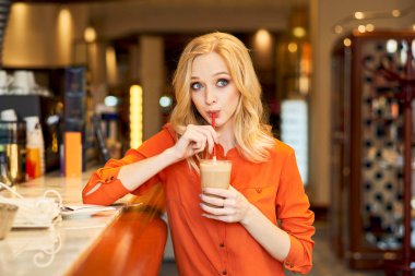 Genç kız tüp oturma çubuğundan kahve içme