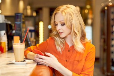 Barda oturan cep telefonu için çalışan genç kız