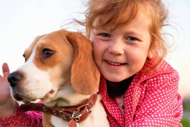 Tatlı küçük çocuk şefkatle güzel köpek sarılma.
