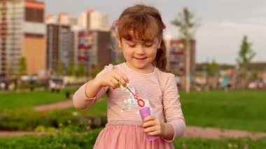 Güzel çocuk yaz akşamı sabun kabarcıkları darbeler.