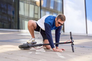 Genç adam onun scooter eğitim sırasında düşüyor.