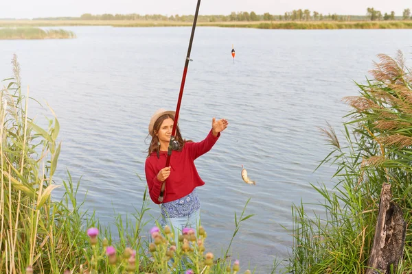 Pesca com vara de pesca em pé na costa do lago — Fotografia de Stock