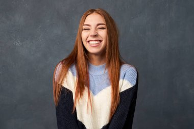 Mutlu bir kadın arka planda kendini izole edilmiş hisseder. Neşeli bir kadın yüksek sesle güler ve burnunu neşeyle kırıştırır..