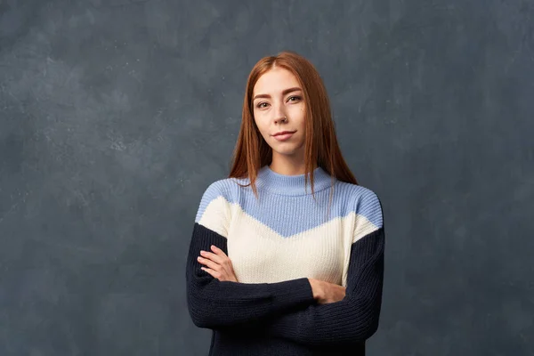 Молода дівчина в теплому синьому светрі ізольована на стіні . — стокове фото