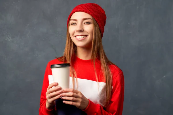 Дівчина тримає чашку кави ізольовано на текстурованій стіні — стокове фото