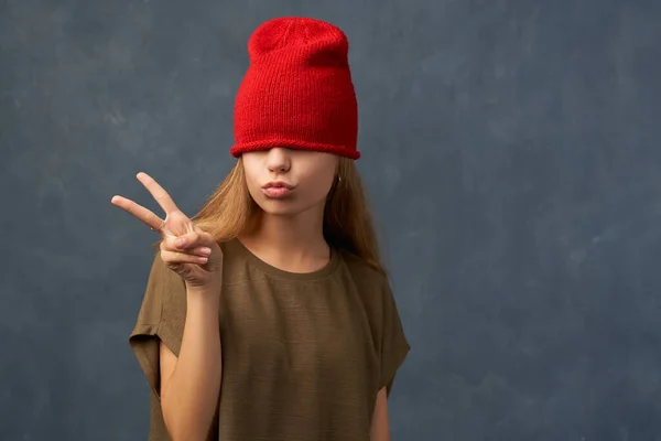 Nastolatek ściągający czerwony kapelusz, zamykający oczy — Zdjęcie stockowe