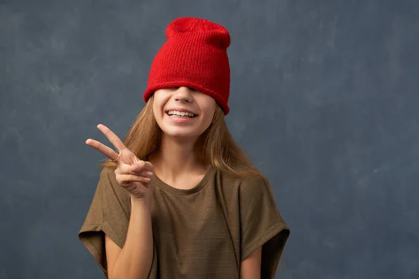 Nastolatek ściągający czerwony kapelusz, zamykający oczy — Zdjęcie stockowe
