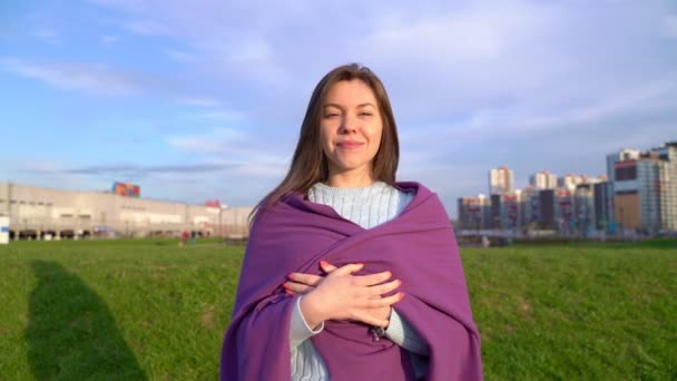 Portret van lachende dame, mooie sneeuwwitte Hollywood glimlach, kijkend naar de camera. Zonnige video van een vrouw die bij zonsondergang in de frisse lucht in Park wandelt. brunette van middelbare leeftijd draagt trui, gewikkeld in ruitjes — Stockvideo