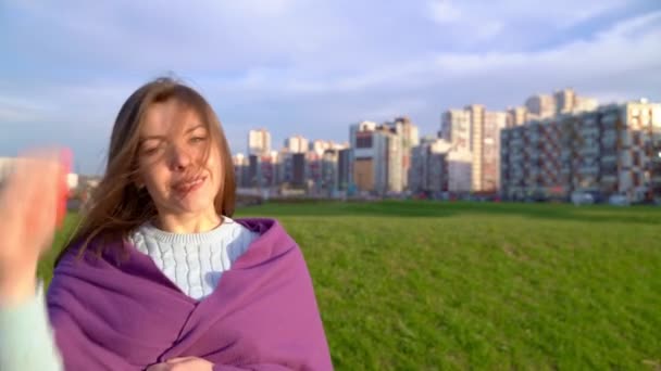 Portret van lachende dame, mooie sneeuwwitte Hollywood glimlach, kijkend naar de camera. Zonnige video van een vrouw die bij zonsondergang in de frisse lucht in Park wandelt. brunette van middelbare leeftijd draagt trui, gewikkeld in ruitjes — Stockvideo