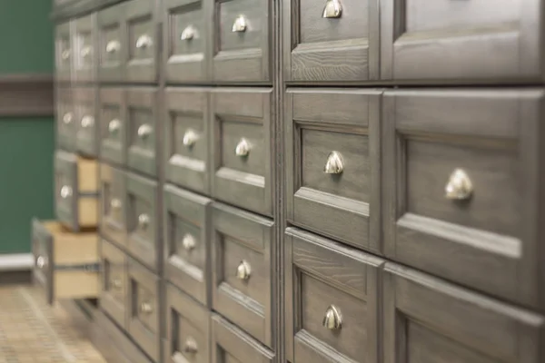 a large number of wooden facades of drawers with iron handles. shallow depth of field.