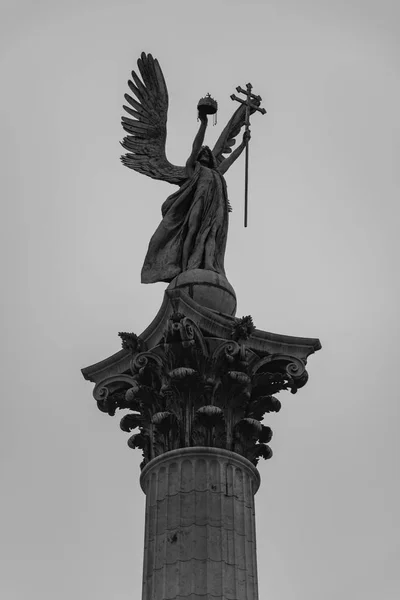 A black and white picture of the statue at the center of the Heroes\' Square (Budapest).
