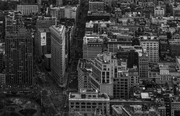 A black and white picture of the Flatiron Building as seen from the Empire State Buulding.