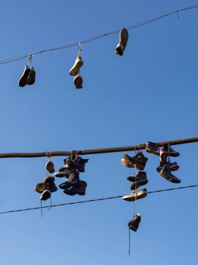 Metelkova Sanat Merkezi 'nde elektrik kablolarına asılı bir çift ayakkabının resmi..
