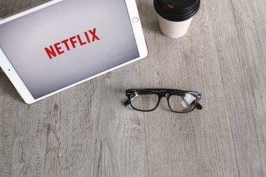 Bangkok, Tayland - 28 Nisan 2018: Netflix app simgesi ipad tablet ekranıyla gözlük ve kahve. Netflix film ve Tv dizisi izlemek için bir uluslararası önemli abonelik hizmetidir.